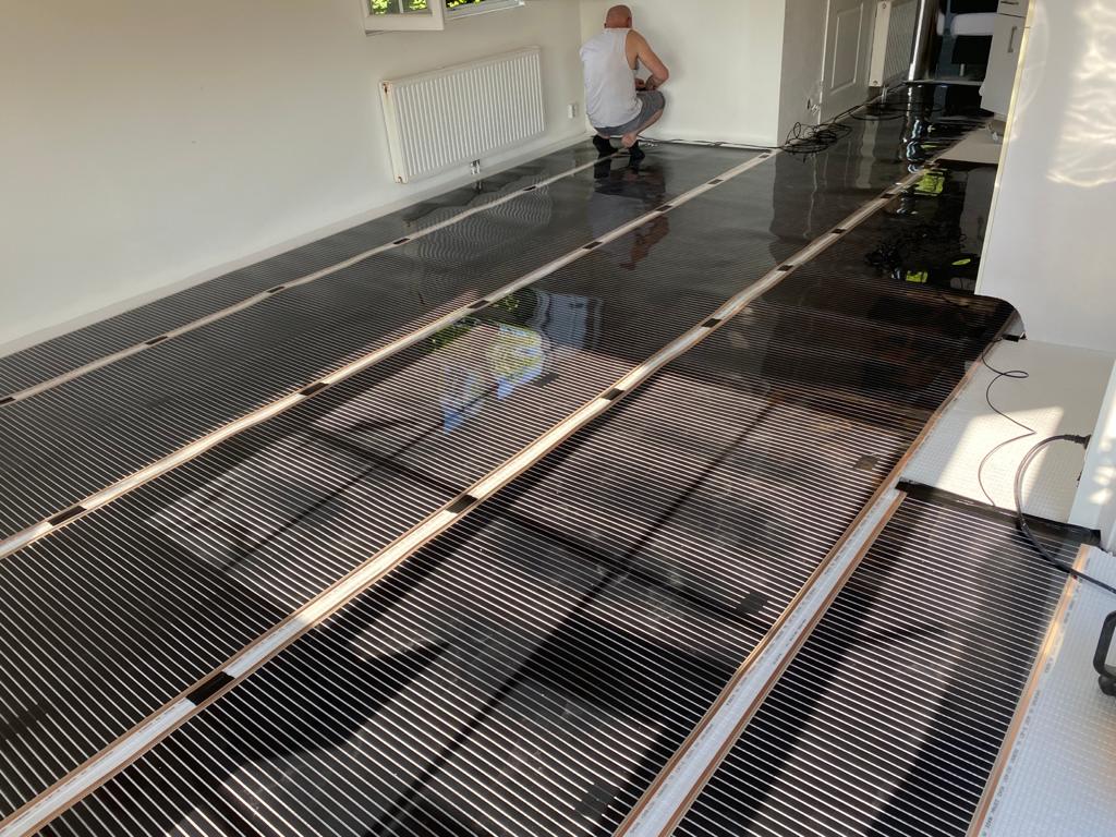 Installatie infrarood verwarmingsfolie in grote woonkamer — carbon verwarmingsfolie uitgerold op XPS ondervloer