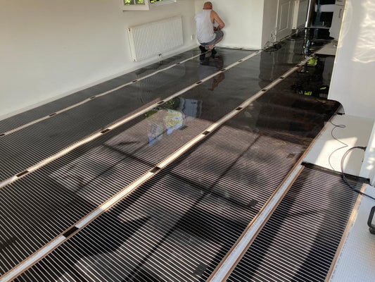 Installatie infrarood verwarmingsfolie in grote woonkamer — carbon verwarmingsfolie uitgerold op XPS ondervloer